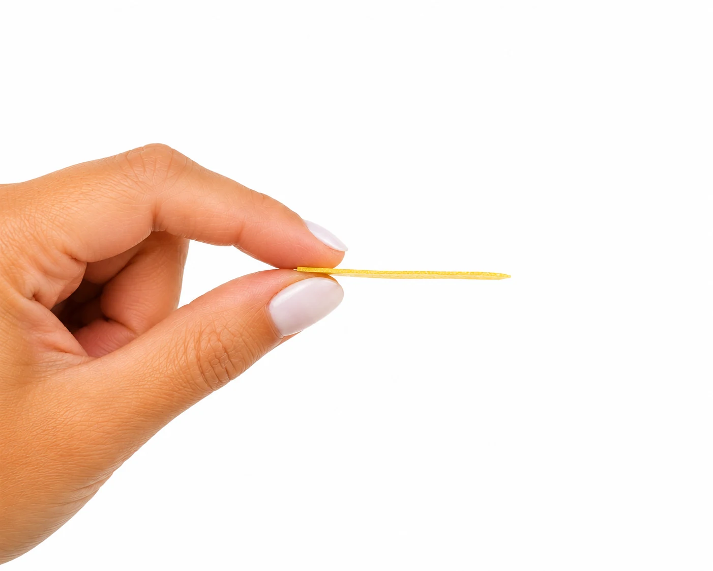 Fingers holding a paper-thin dissolving strip
